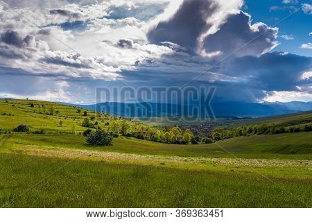 Small , Hungarian Transylvanian Village At Sunset With Gathering Stormclouds In Romania.