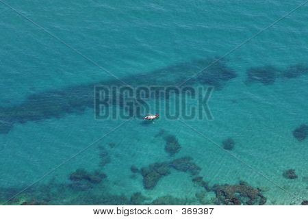 Luftfoto af klare blå vand og den gule båd
