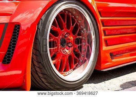 Red Sports Tuned Car Rear View Of The Wheel, Close-up . Fashion Car Day On The Road