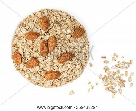 Oatflakes In A Bowl  Isolated On White Background. Pile Of Oatmeal With Almond Nuts  Top View. Macro