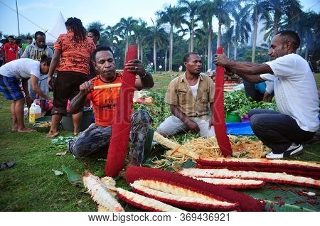 Jakarta, Indonesia - May 25, 2014 : Papua People Peeling Red Fruit At The Festival Papua In Monas, J