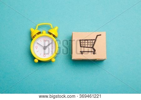 Delievery Box And Yellow Alarm Clock. Express Delivery Concept. Temporary Storage, Limited Offer And