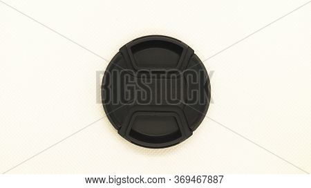 Black Protective Cap For The Camera Lens Close-up On A White Background. Photographer Equipment. The