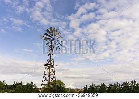 The Old Rusting Steel Windmill Is A Machine For Producing Continuous Power From Wind And Air, In Whi