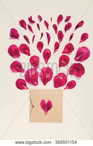 Petals Of Dark Red Peony In Shape Of Heart With Craft Envelope On White Background. Blank Card For I