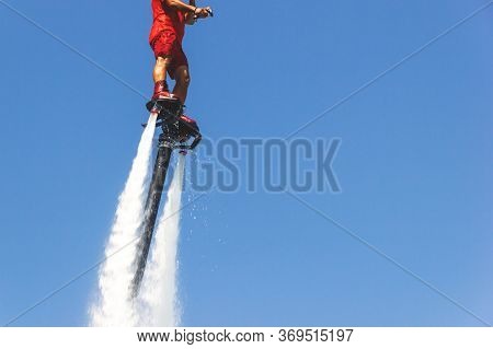 Fly Board, Man On A Flyboard In Red. Water Extreme Sport. The Guy Is Flying At The Aquatic Flyboard.