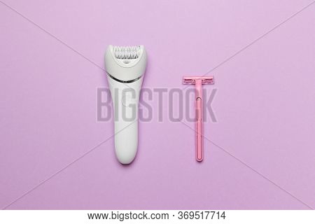 Women Epilator And Pink Razor On Purple Colored Paper Background, Top View.