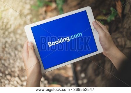 Rayong, Thailand, Apr 12,2020: Asian Man Holding Apple Ipad To Use Booking.com Application To Reserv