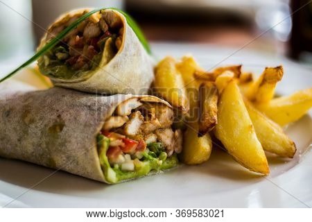 Tasty Wraps With Chicken, Avocado, Lettuce And French Fries On A Plate. Selective Focus
