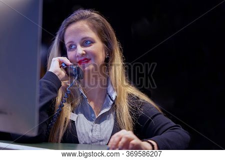 Woman Answers Customer Calls In A Call Center. The Secretary Answers The Phone And Talks With Client