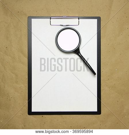 A Tablet With A White Sheet Of A4 Format With Magnifier On A Beige Craft Paper. Concept Of Analysis,