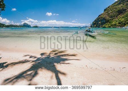 Beautiful Scenery Of Corong Corong Beach With Traditional Boat And Palm Shadow. El Nido, Palawan Isl