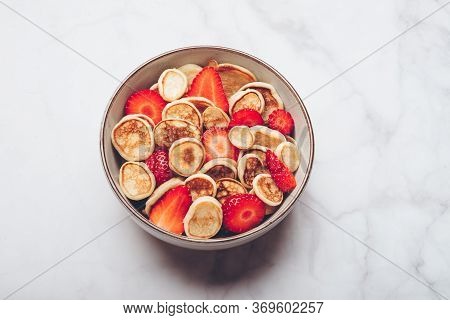 Trendy Home Breakfast With Tiny Cereal Pancakes With Piece Of Butter And Fresh Strawberries In The B
