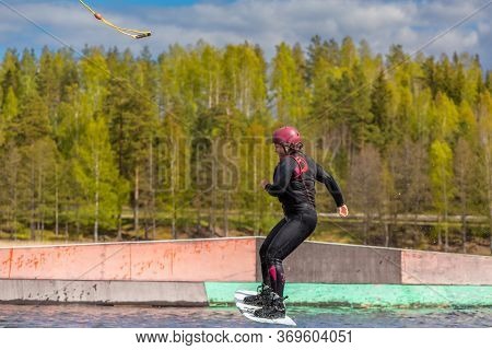 Fagersta, Sweden - Maj 26, 2020: Wakeboarder Teen Girl Make An Extreme Jump On Wakeboard, Around The