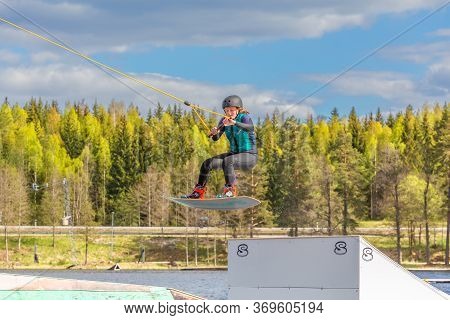 Fagersta, Sweden - Maj 26, 2020: Wakeboarder Flies In The Air On Wakeboard. Wakeboarding Is Extreme 
