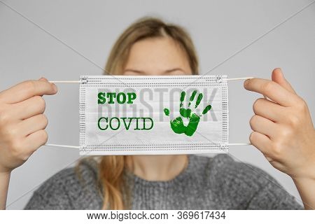 Girl Holds A Medical Mask In The Face.stop Covid.