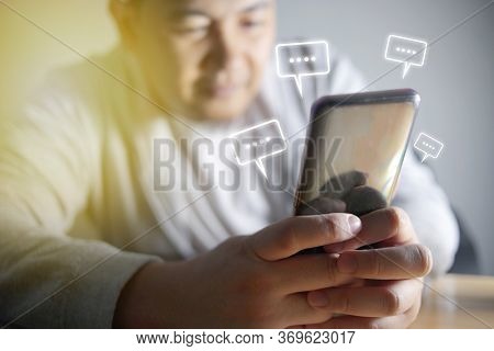 Asian Man Sending Text Message And Sms With Smartphone. Guy Texting And Using Mobile Phone Late At N