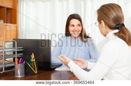 Senior Woman Answer Questions Of Social Worker At Home