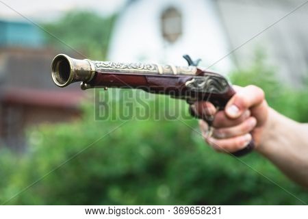 Old Musket Gun In A Pirate Hand Close Up. Duel.