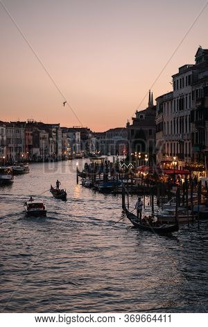 Gondoliers At Dusk On The Grand Canal Of Venice, Italy.