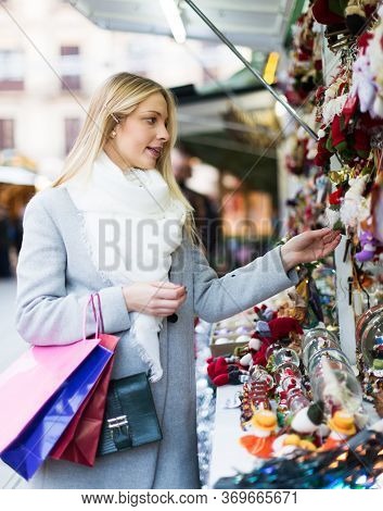 Portrait Of Female Customer Near Counter With Christmas Gifts On Fair
