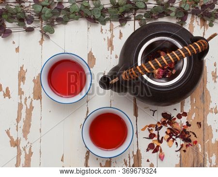 A High View Of Rosehip Tisane With A Teapot Small Cups And Loose Leaves