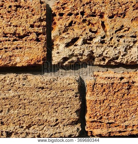 Brick Wall Of Yellow Shell Rock. Closeup Of Shellstone Texture. Background.