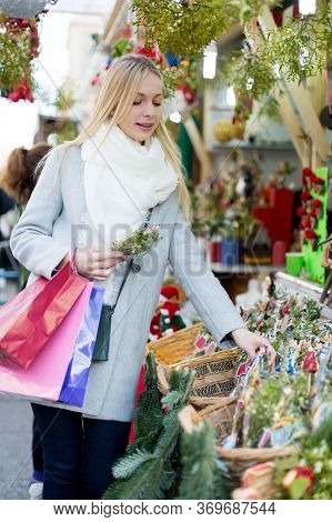 Happy Girl Staying Near Counter With Mistletoe At Xmas Fair