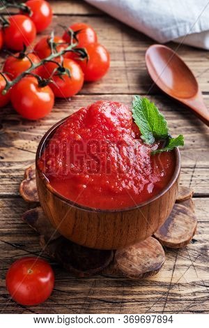 Tomatoes In Their Own Juice Or Tomato Paste In A Wooden Bowl And Fresh Tomatoes On A Rustic Wooden T