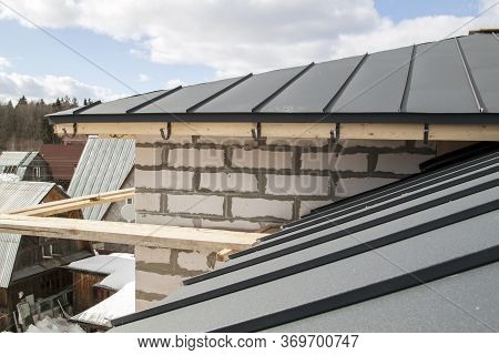 Close Up View Of Scaffolding And House Under Construction With Grey Folding Roof On Waterproofing La