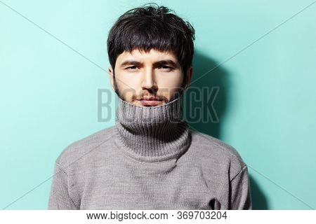 Studio Portrait Of Young Guy Wearing Sweater On Background Of Aqua Menthe Color.