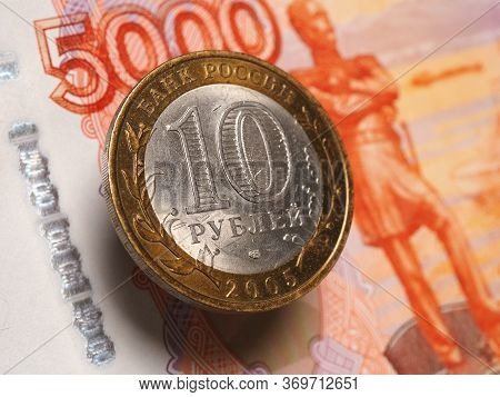 Russian Bimetallic Coin Of 10 Rubles Hangs In The Air Above The 5000 Ruble Note