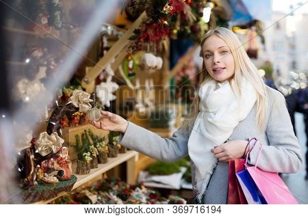 Young Smiling Woman Chooses Souvenirs At The Christmas Market