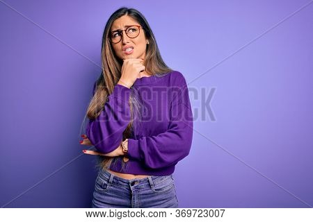 Young beautiful smart woman wearing glasses over purple isolated background Thinking worried about a question, concerned and nervous with hand on chin