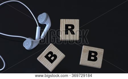 Brb (i'll Be Right Back) - Acronym On Wooden Cubes On A Black Background With Headphones