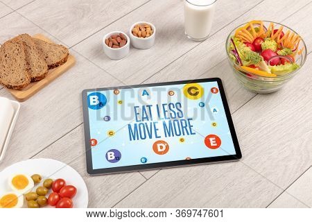 Healthy Tablet Pc compostion with EAT LESS MOVE MORE inscription, weight loss concept
