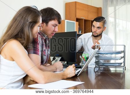Serious Bank Employee Trying Hard To Make Young Couple Pay Back A Loan