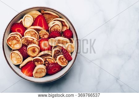Trendy Home Breakfast With Tiny Cereal Pancakes With Piece Of Butter And Fresh Strawberries In The B
