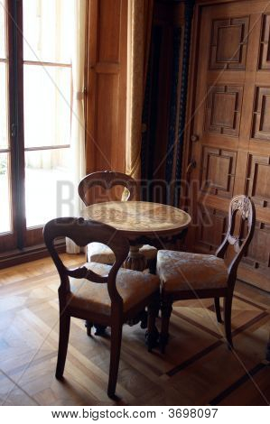 Interno con tavolo e tre sedie