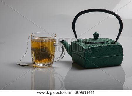 A Green Teapot And A Cup Of Green Tea