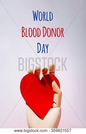 Wooden Hand With Big Red Heart In A Giving Gesture. World Blood Donor Day Wording. Donation, Help, H