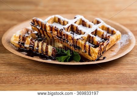 Viennese Waffles On A Disposable Plate With Peanut Butter, Icing Sugar And Mint.