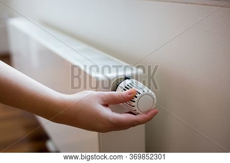 Woman Changing The Temperature On Radiator By Temperature Controller, Increase Or Decrease The Price