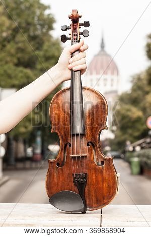 Violin In Budapest In Female Hands In Front Of Parliament