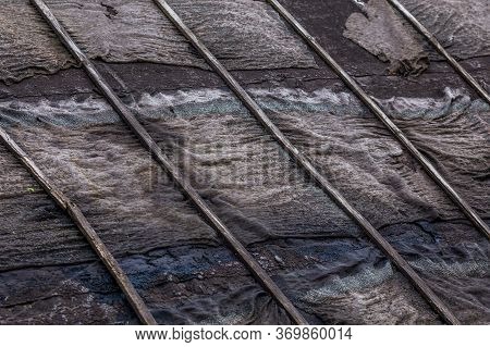 Old Rotten Black Ruberoid Shed Gable Roofing Close-up With Selective Focus And Blur