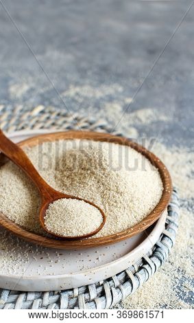 Raw Uncooked Fonio Seeds With A Spoon On A Plate On Grey Background Close Up With Copy Space