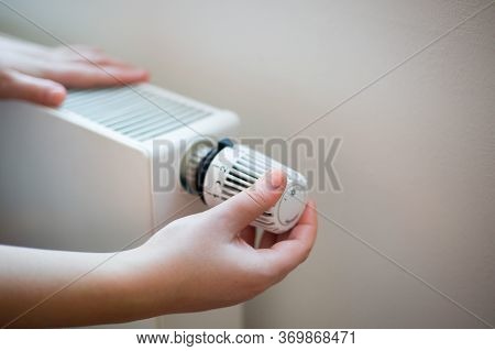 Woman Changing The Temperature On Radiator By Temperature Controller, Increase Or Decrease The Price