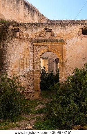 Abandoned Old Ruined Building. Gate With An Arc Without Door. Ruined Facade Of The Walls. Dar Caid H