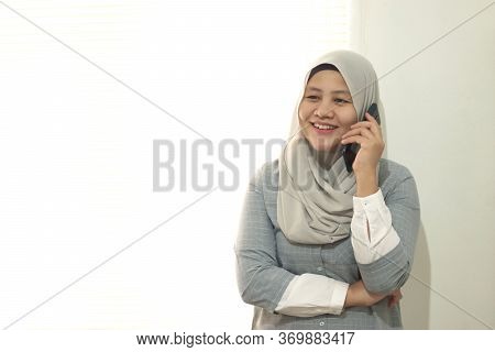 Portrait Of A Phappy Successful Asian Muslim Businesswoman Call Someone On Mobile Phone, Talking And