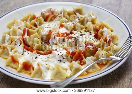 manti ( turkish ravioli type dumplings )served with garlic yoghurt, melted aleppo pepper butter and dry mint and sumac